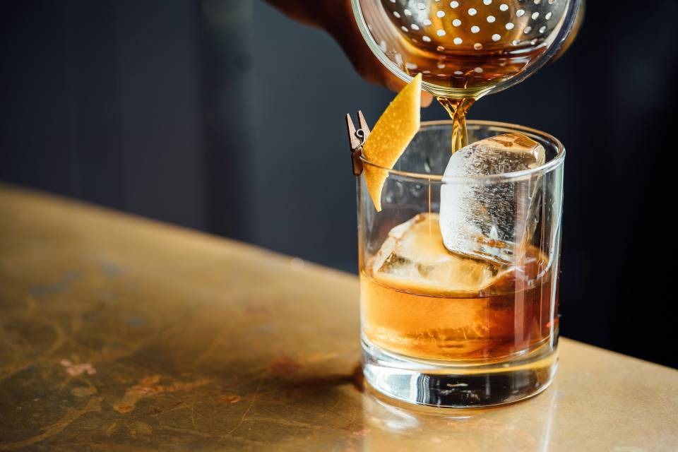 Whisky Glas mit Eiswürfel und Zitronenzeste